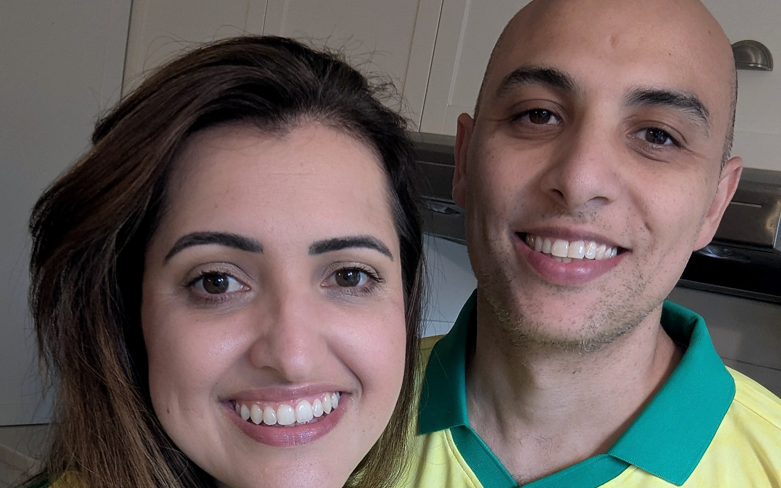 The founder and his wife at home in their kitchen, smiling.